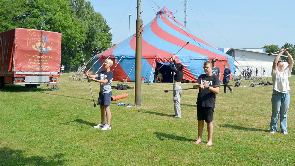 Mit Feuerfackeln tritt diese jahrgangsgemischte Gruppe auf. Vor dem Zirkuszelt wird erst einmal ohne offene Flamme geübt. Foto: Fertig