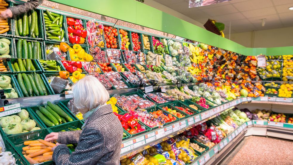 Eine Kundin packt frisches Gemüse in einen Einkaufskorb. Discounter und Supermärkte wollen nachhaltiger ihr Sortiment bestücken und so weniger Abfälle produzieren. Foto: dpa/Jens Büttner