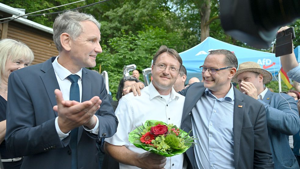 Björn Höcke (links), Vorsitzender der AfD Thüringen und Tino Chrupalla, AfD-Bundesvorsitzender (rechts) gratulieren Robert Sesselmann. Foto: dpa/Martin Schutt