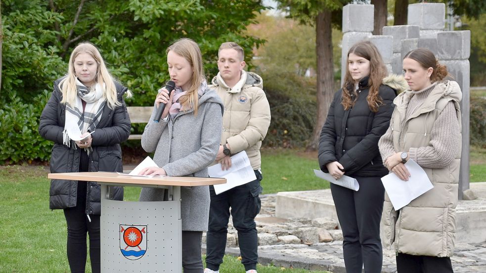 Kirsten Beening (am Mikrofon), Pressesprecherin der Gemeinde Westoverledingen, und Auszubildende der Gemeinde trugen Porträts der 13 ehemaligen jüdischen Mitbürger vor. Foto: Ammermann