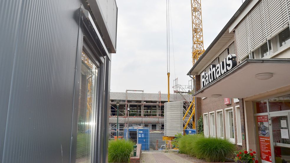 Das Rathaus in Barßel (rechts) ist in die Jahre gekommen. Es wird durch einen Neubau ersetzt (hinten Mitte). Bis er fertig ist, arbeitet die Belegschaft im Rathaus auch schon mal in einem Container (links), der auf dem Vorplatz des Verwaltungsgebäudes aufgestellt ist. Foto: Fertig