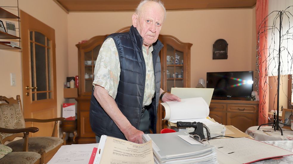 Arno Conrads vor einem Aktenberg: Geblieben sind ihm 139 Röntgenbilder seiner Wirbelsäule, die nun im Aktenschrank in Elisabethfehn verstauben. Foto: Passmann