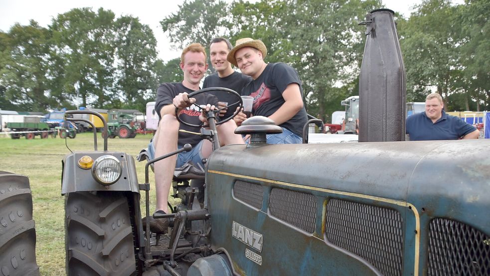 Mit einem Lanz Bulldog aus dem Jahr 1958 war Jann-Alexander Renken (von links) aus Schwerinsdorf nach Flachsmeer gekommen. Mit beim Traktor sind Jannes Wiemers aus Spetzerfehn und Jesko Wilken aus Beeningafehn. Foto: Ammermann