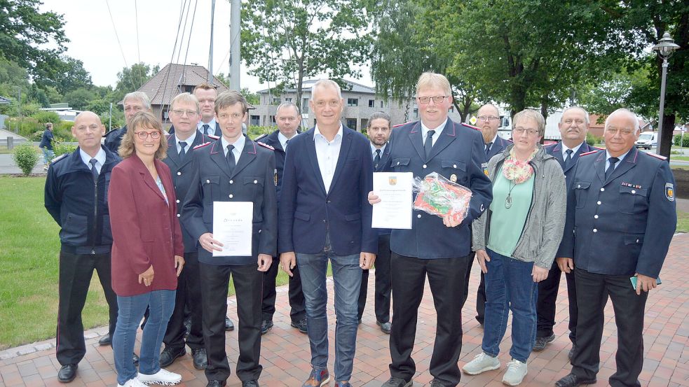 Osrhauderfehns Bürgermeister Günter Harders (vordere Reihe Mitte) entband Hinrich Kleemann (vorne rechts mit Urkunde) von seinen Pflichten als Ortsbrandmeister von Potshausen. Zu dessen Nachfolger wurde Carsten Jelden (links, mit Urkunde) ernannt. Im Hintergrund sind Potshausens Ortsvorsteherin Helga Meyer (links) und die Vertreter des Ortskommandos der Gemeinde Ostrhauderfehn zu sehen. Foto: Weers