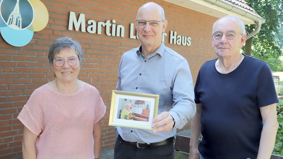 Der Vorstand von „Stöppkes“ mit einem Foto, auf dem die Verstorbene Erna Modler an einem Klavier sitzt :(von links) Mariechen Murra, Vorsitzender Thomas Perzul und Günter Streppe. Foto: Kruse