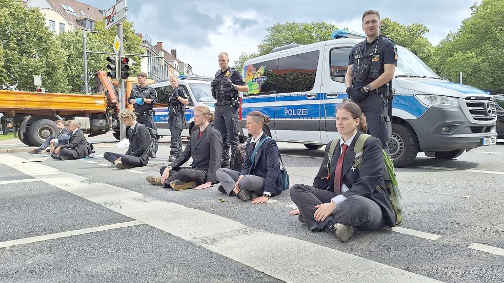 Nichts geht mehr: In Bremen haben sich vier Aktivisiten auf die Straße am Rande der Wallanlagen geklebt. Drei weitere setzten sich auf die Fahrbahn, ohne sich festzukleben. Foto: NWM-TV