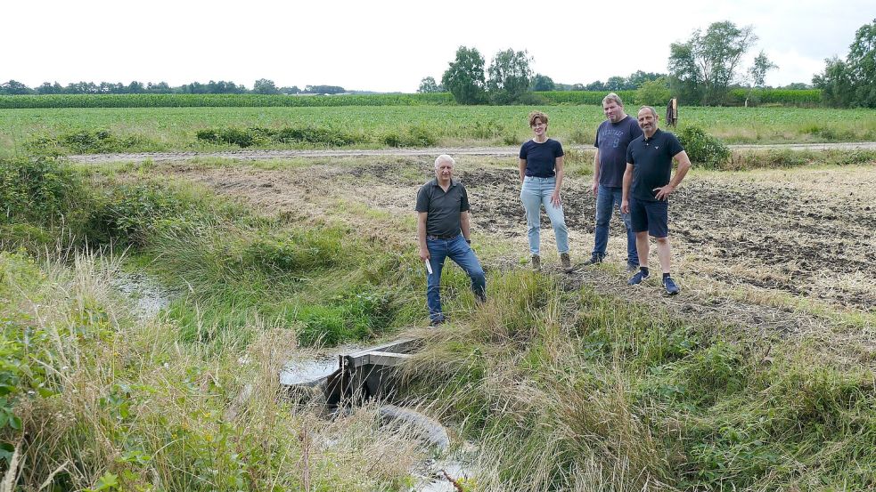 Mit den ersten Ergebnissen des Wassermanagementprojekts, bei dem ein kleines Wehr den Wasserabfluss unter rund 400 Hektar Boden reguliert, sind (von links) Martin Windhaus (Geschäftsführer der Friesoyther Wasseracht) sowie die Landwirte Anne Preut, Hubert Anneken und Elmar Preut zufrieden. Foto: Stix