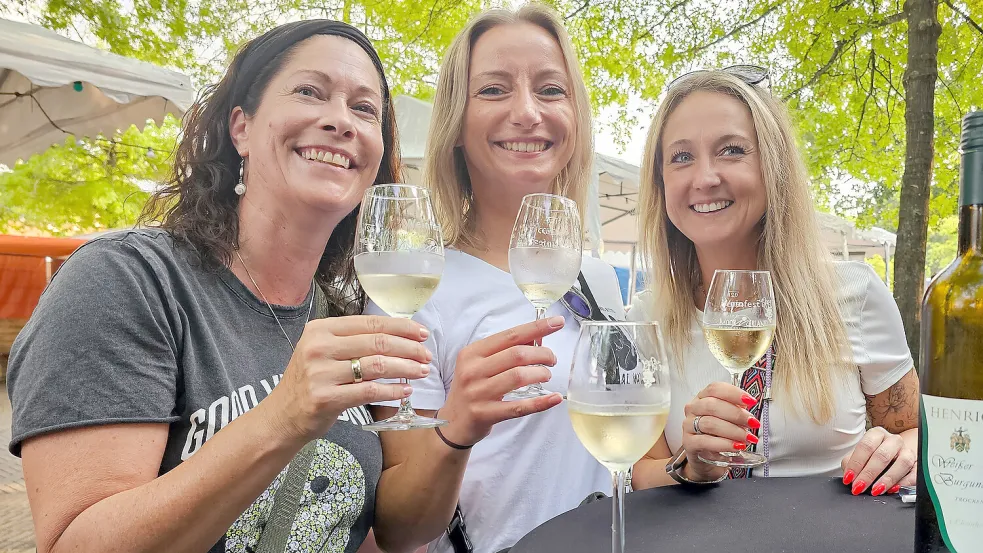 Rebekka Sczimarowski aus Moormerland stieß mit ihren Freundinnen Lydia Günter und Sarah Schmitz aus Dortmund an. Diese reisten zum wiederholten Mal zum Weinfest an. Foto: Stromann