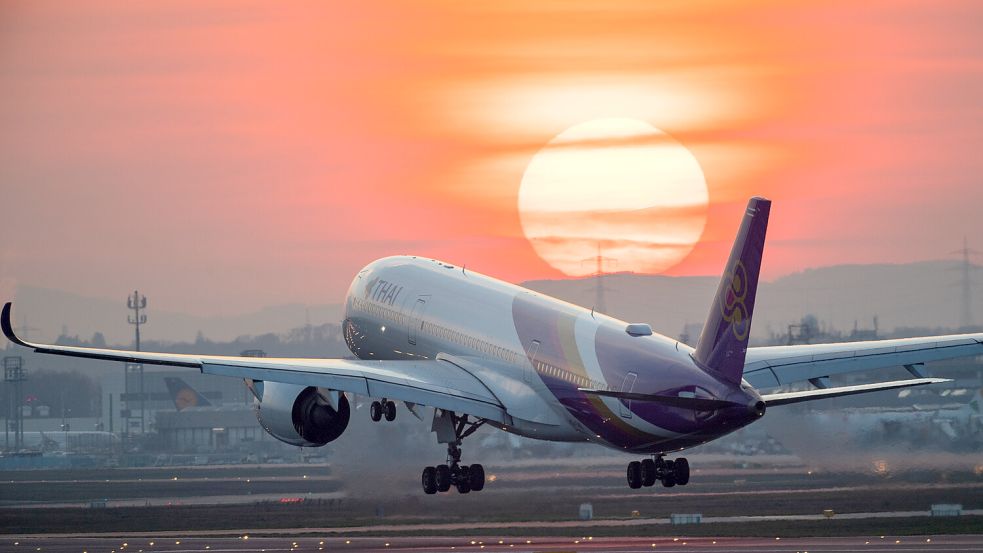 Ein Airbus A350 landet bei Sonnenuntergang auf dem Frankfurter Flughafen. Der Luftverkehr ist laut Forschern für bis zu 3,5 Prozent der globalen Emissionen verantwortlich. Foto: picture alliance/dpa/Arne Dedert