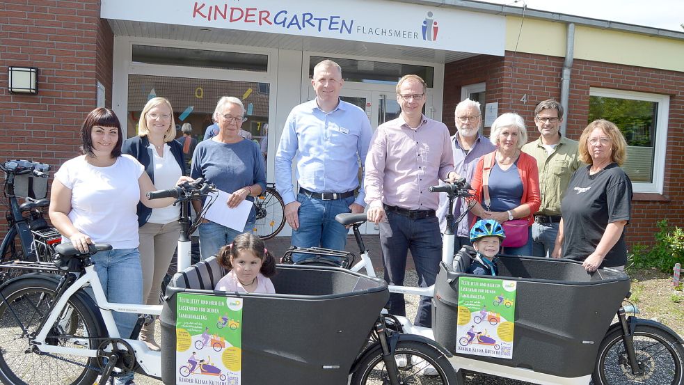 „Kinder Klima Kutsche“ heiß ein neues Projekt in Flachsmeer und Völlenerkönigsfehn. Der evangelisch-lutherische Kindergarten in Flachsmeer und die katholische Kinderkrippe St. Bonifatius haben jeweils zwei sogenannte Caro-Bikes erhalten, die von den Eltern gegen eine symbolische Leihgebühr von 10 Euro pro Woche genutzt werden können. Das von Sponsoren unterstützte Projekt trägt den Namen „Kinder Klima Kutsche“. Das Foto zeigt (von links) Krystyna Havrylova (Mutter), Wiebke Bluwatsch (Raiffeisenbank Flachsmeer), Gitta Hoheisel (Leiterin des evangelisch-lutherischen Kindergartens Flachsmeer), Hermann Vierdag (Radwelt Emsland Papenburg), Sebastian Sanders (Vater), Detlef Hermann, Hedwig Daute, Dr. Marcus Stieger und Claudia Spendel (alle vom Organisationsteam). Im Vordergrund sind die Kinder Kira Havrylova und Erik Sanders zu sehen. Foto: Weers