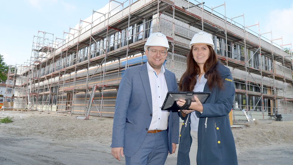 Barßels Bürgermeister Nils Anhuth und Maja Peters, Bautechnikerin der Gemeinde, vor dem Rohbau des Verwaltungstrakts, der im ersten Bauabschnitt direkt neben dem alten Barßeler Rathaus in der Ortsmitte des Kernorts entsteht. Foto: Fertig