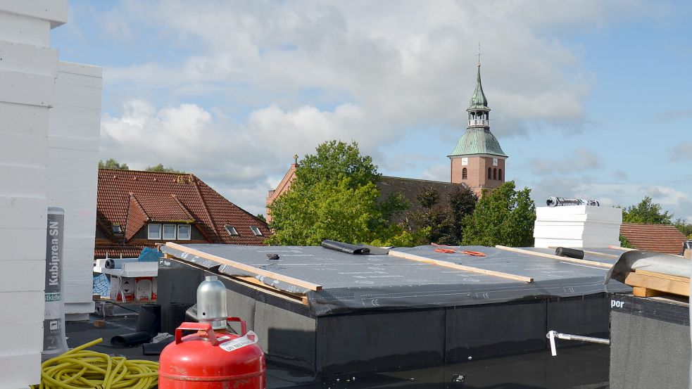 Über den Dächern von Barßel mit freier Sicht auf den Kirchturm der Pfarrkirche Ss. Cosmas und Damian: Diesen Überblick gewinnt man vom Dach des Rohbaus aus. Später wird das Flachdach vollflächig mit Fotovoltaik ausgestatte Foto: Fertig