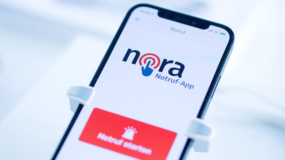 Die Notruf-App Nora ist auf dem Display eines Mobiltelefones zu sehen. Die App ist eine Ergänzung zu den Notrufnummern 110 und 112 von Polizei, Feuerwehr und Rettungsdiensten und richtet sich vor allem an Menschen mit einer Hör- und Sprachbehinderung. Foto: Vennenbernd/dpa