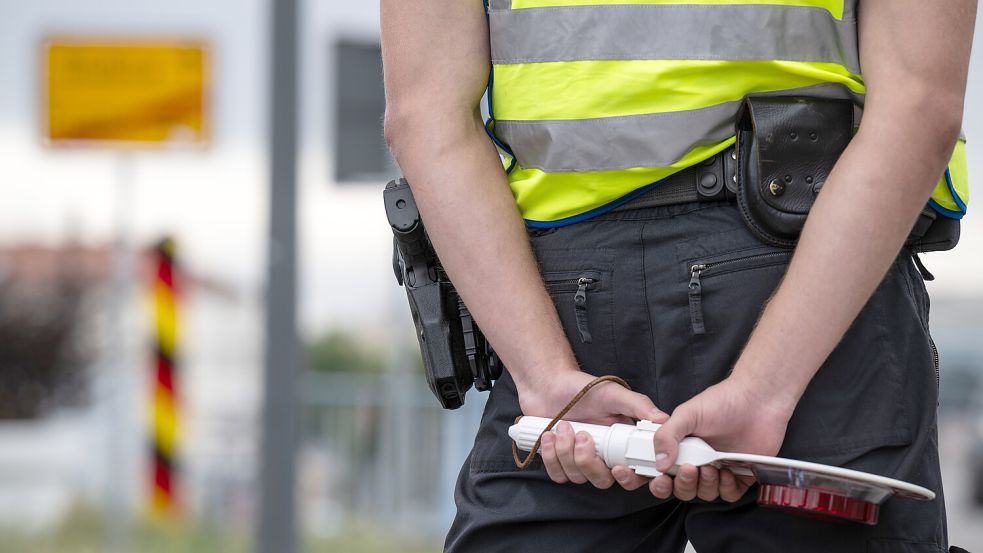 Ein Polizist mit Haltekelle in den Händen steht an der deutsch-polnischen Grenze. Foto: dpa/Hannes P. Albert