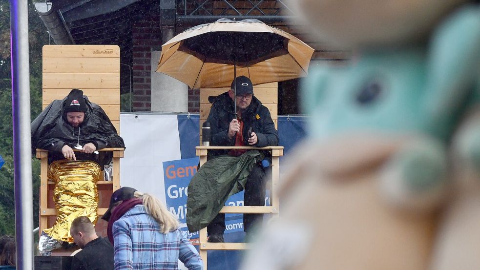 Die Teilnehmer auf dem Fehntjer Markt sitzen im Regen – sind aber nur noch zu acht. Fotos: Hellmers