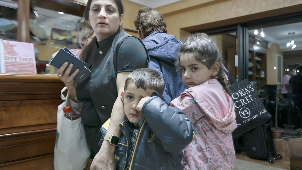 Eine Familie aus Berg-Karabach, ethnische Armenier, warten darauf, vorübergehend in einem armenischen Hotel untergebracht zu werden. Foto: dpa/AP/Vasily Krestyaninov