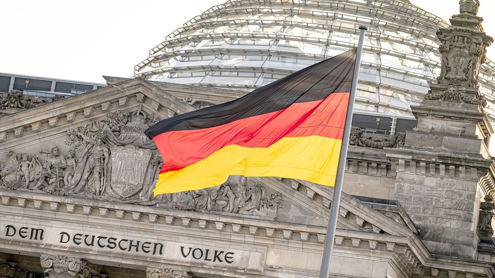 Die deutsche Flagge weht vor dem Reichstagsgebäude am Jahrestag der Wiedervereinigung der beiden deutschen Staaten. Foto: Fabian Sommer/dpa