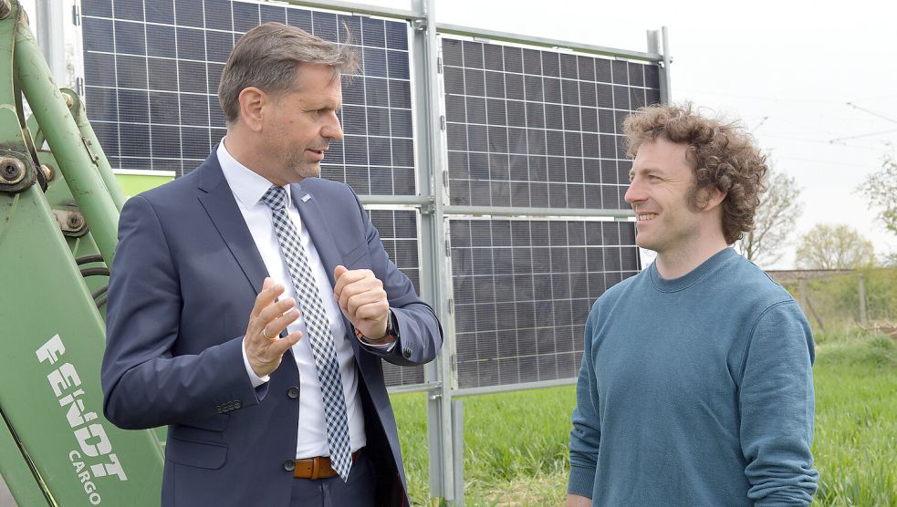 Niedersachsens Minister Olaf Lies (links) besichtigte im Jahr 2022 das Pilotprojekt „Agri-PV Dörverden“, bei dem senkrecht aufgestellte Solarmodule auf der Ackerfläche platziert werden. Der Minister unterhält sich auf dem Foto mit mit Corbinian Schöfiniu von der Klimaschutz- und Energieagentur Landkreis Verden. Archivfoto: Michael Bahlo/dpa