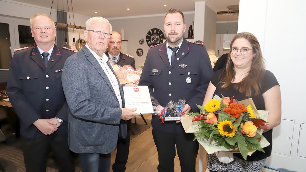 Der stellvertretende Bürgermeister Johannes Geesen (2. von links) überreichte das Ehrenzeichen an Henning Hibben (2. von rechts). Blumen gab es für Ehefrau Annika Hibben. Von der Feuerwehr gratulierten Uwe Schröder (links) und Mario Kruse (Mitte). Foto: Passmann