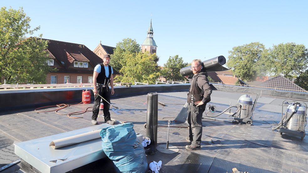 Auf dem Flachdach verlegen Dachdecker die Bitumenschweißbahnen. Gute Sicht hat man von dort auch die Kirche. Foto: Passmann