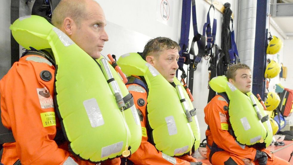 Verschnaufpause: Die angehenden Servicetechniker für Offshore-Windkraftanlagen André Ullert (Mitte) und Luka (rechts) und Risikoingenieur Oliver Höck (links) bei einem Kursus für das Überleben auf See. Höck ist nach eigenen Angaben schon seit rund zehn Jahren für den Versicherer Allianz Commercial immer wieder auf Offshore-Umspannplattformen unterwegs und sagt: „Die Trainings hier, in kontrollierter Umgebung, mit geschultem Personal an der Seite, die bringen uns Teilnehmer an die Grenze. Ich will mir gar nicht ausmalen, wie das da draußen ist, wenn es wirklich mal ernst ist.“ Foto: Saure