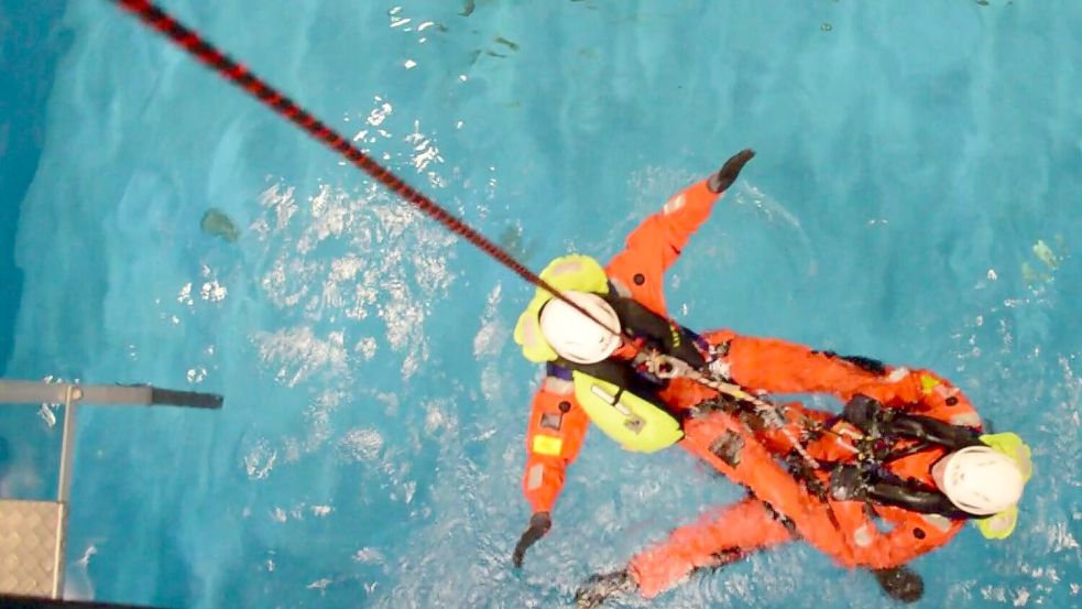 Wärmer als draußen: Die angehenden Servicetechniker für Offshore-Windkraftanlagen André Ullert und Luka bei ihrem Kursus für das Überleben auf See in Bremerhaven. Im Vergleich zur Nordsee ist das Wasser im Schwimmbecken wärmer, laut Kursanbieter RelyOn Nutec liegt die Temperatur um die 27 Grad Celsius. Foto: Saure
