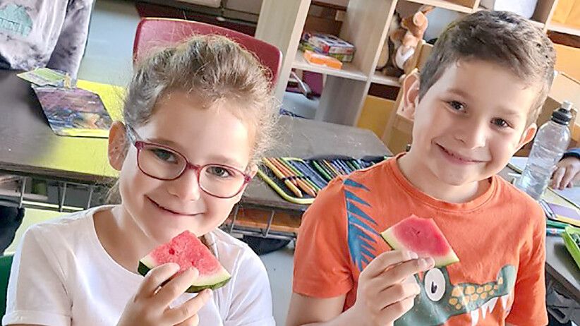 Pia und Mika aus der Klasse 2a der Marienschule Strücklingen lassen sich ein Stück Melone schmecken. Foto: Olling/Marienschule Strücklingen