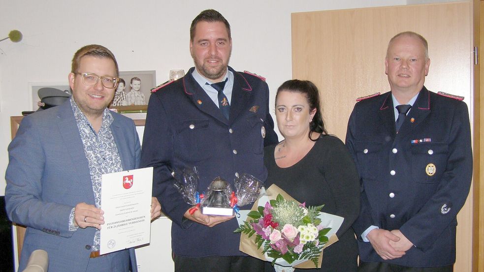 Bürgermeister Nils Anhuth (von links) überreichte Simon Goesmann die Urkunde. Für Ehefrau Vivien gabes den Blumenstrauß von Gemeindebrandmeister Uwe Schröder. Foto: Passmann