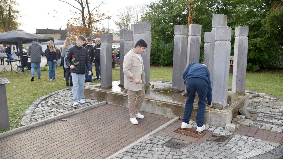 An der Gedenkfeier beim Denkmal in Ihrhove wirkten auch Schüler des Schulzentrums Collhusen mit. Sie lasen Kurzporträts der 13 ehemaligen jüdischen Mitbürger vor, die in Westoverledingen gelebt haben. Anschließend legten sie bei den 13 Stelen rote Rosen nieder. Foto: Ammermann