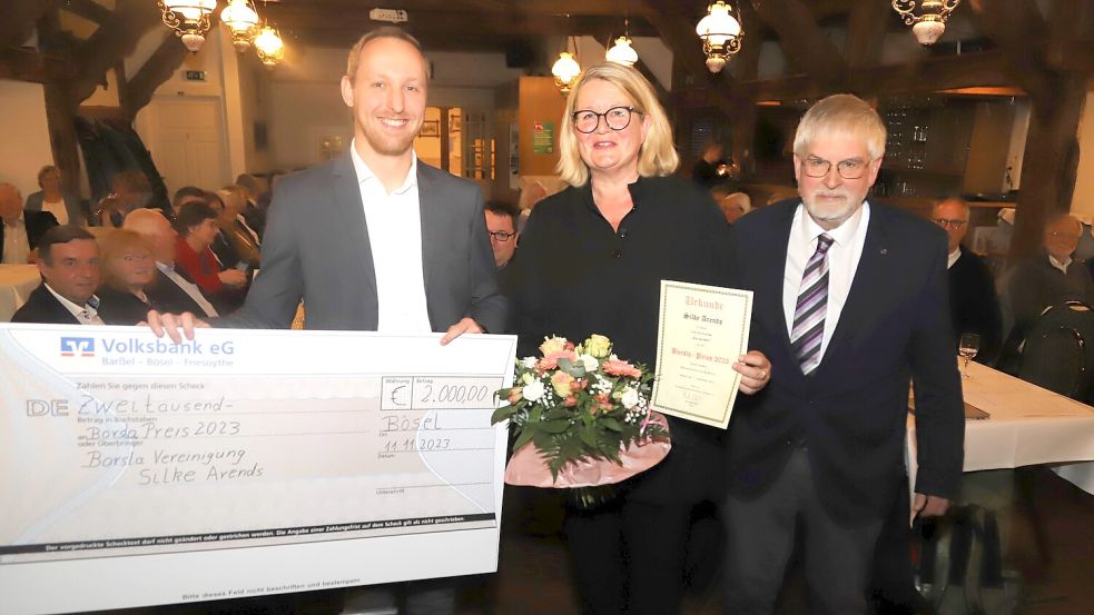 Borsla-Preis 2023: Der Vertreter der Volksband Barßel-Bösel-Friesoythe, Matthias Latta (links), und Borsla-Vörsitter Dr. Josef Willer (rechts) überreichten Urkunde und Scheck an die Preisträgerin Silke Arends aus Emden. Foto: Passmann