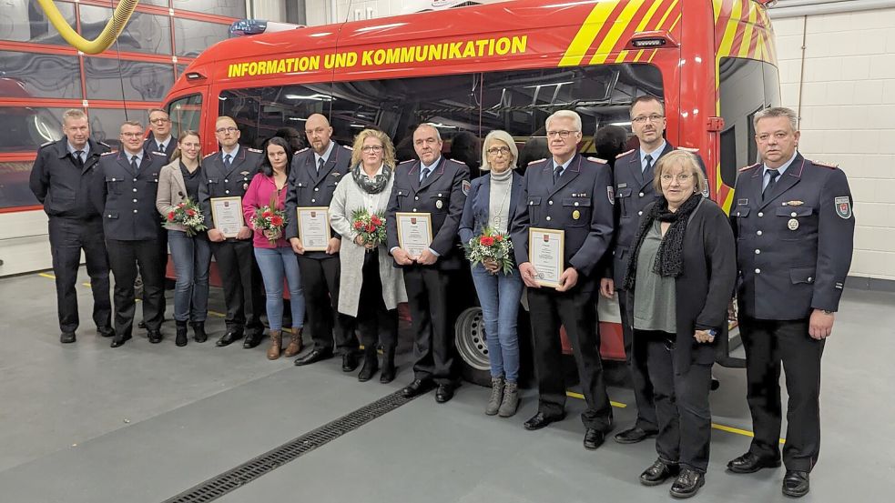 Die Geehrten stellten sich gemeinsam mit ihren Partnerinnen und Vertretern der Feuerwehr sowie mit Gabriele Ostholthoff, stellvertretende Bürgermeisterin der Gemeinde Westoverledingen, zum Gruppenfoto auf. Foto: Bruns/Feuerwehr