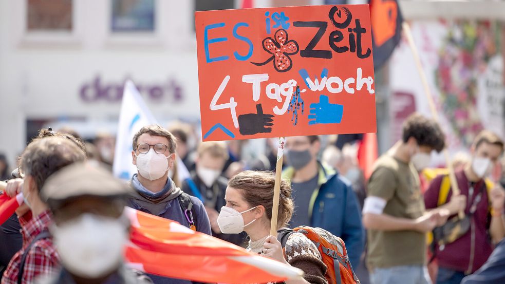 Bei einer Mai-Kundgebung in Erfurt wird auf einem Schild die Vier-Tage-Woche gefordert. Foto: Reichel/ZB/DPA