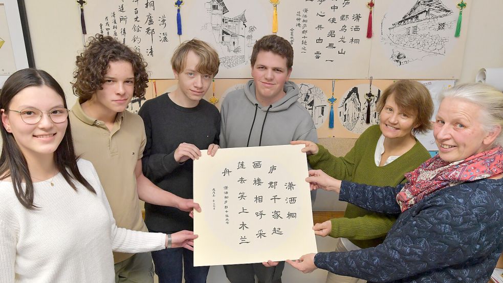 Li Sha Wendt (von links), Lasse Book, Lennart Hartmann und Arne Koenen haben die HSK-Prüfung bestanden. Auf dem Bild fehlt Greta Joecks. Gemeinsam mit Schulleiterin Ute Wieligmann und Lehrerin Caroline Hecht zeigen sie chinesische Schriftzeichen. Foto: Ortgies