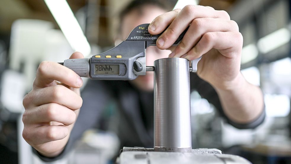 Ein Auszubildender im Metall-Handwerk misst in einem Ausbildungszentrum die Dicke eines Werkstücks. Foto: Kästle/DPA