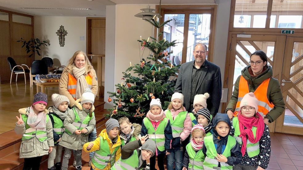 Posieren für das Erinnerungsfoto im Rathaus: Jungen und Mädchen des Kindergartens „Seelterfoakse“ haben den Weihnachtsbaum im Rathaus geschmückt. Bürgermeister Thomas Otto freute sich sehr darüber. Foto: Kruse