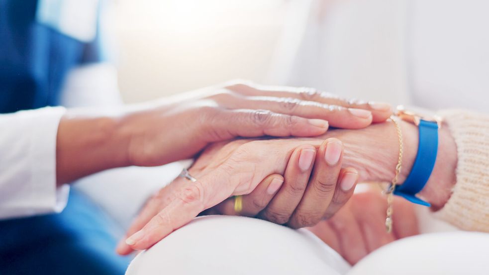 Eine Pflegerin hält die Hand einer Senioren. In Pflegeheimen werden Sie rund um die Uhr versorgt. Das betrifft sowohl die körperliche und mentale Pflege als auch die hauswirtschaftliche Versorgung. Auch zuhause gepflegt zu werden kann seine Vorteile haben. Foto: imago images/Zoonar II