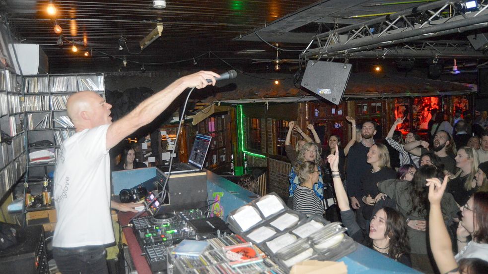 DJ Marco Hanneken in seinem Element: Er singt bei den Liedern selbst mit und animiert so das Publikum in der Ihrhover Diskothek Limit zum Tanzen. Foto: Weers