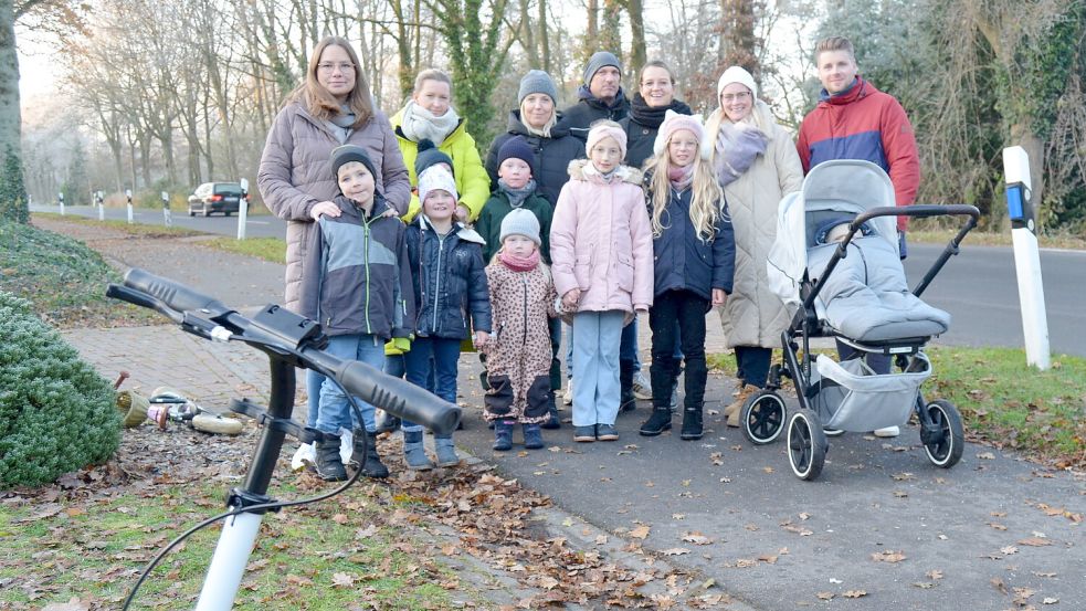 Sie alle sind am Patersweg-Nord in Ihren zu Hause: (von links) Niklas mit Mutter Janina Meeuw, Nicole Graß mit Felix (verdeckt), Emma, Ida, Lina und Eni (vorne) sowie (hintere Reihe) Lisa Venenga mit Sohn Henri, Thomas und Nicole Oltmanns sowie Grietje Werkmeister und Tebbe Bertus mit Söhnchen Freyd im Kinderwagen. Die jungen Familien wünschen sich zur Sicherheit ihrer Kinder Laternen entlang der Straße und Tempo 50. Foto: Fertig