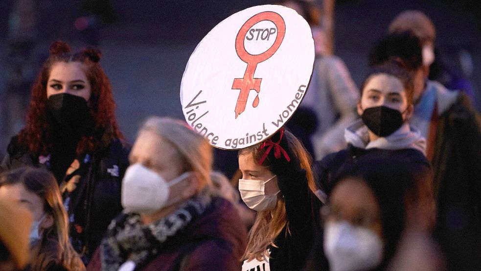 Gegen Gewalt an Frauen demonstrieren auch diese Menschen in Berlin vor dem Brandenburger Tor. „Stop Violence against Women“ („Stop mit der Gewalt gegenüber Frauen“) steht auf ihrem Plakat. Foto: Riedl / DPA