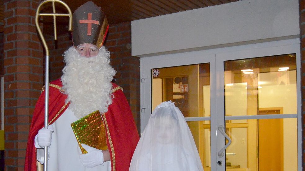 Im Saterland sind die Nikoläuse unterwegs. Hier steht einer von vier Nikoläusen mit seinem Engelein, die am Dienstag, dem Vorabend des Nikolaustages, vom Pfarrheim Ramsloh aus zu ihrer Tour durch Ramsloh gestartet sind. Am Nikolaustag selbst, Mittwoch, 6. Dezember, sind weitere fünf Ehrenamtliche im Gewand des legendären Bischofs von Myra unterwegs, um Kinder in Ramsloh zu besuchen und zu beschenken. Foto: Fertig