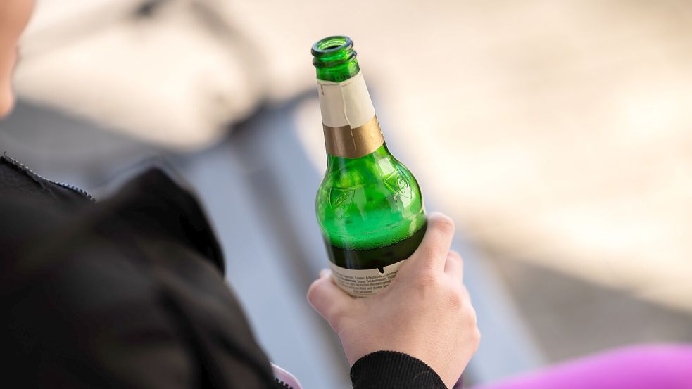 Eine Jugendliche hält vor ihrem Haus eine Flasche Bier in der Hand. Symbolfoto: Stein/DPA