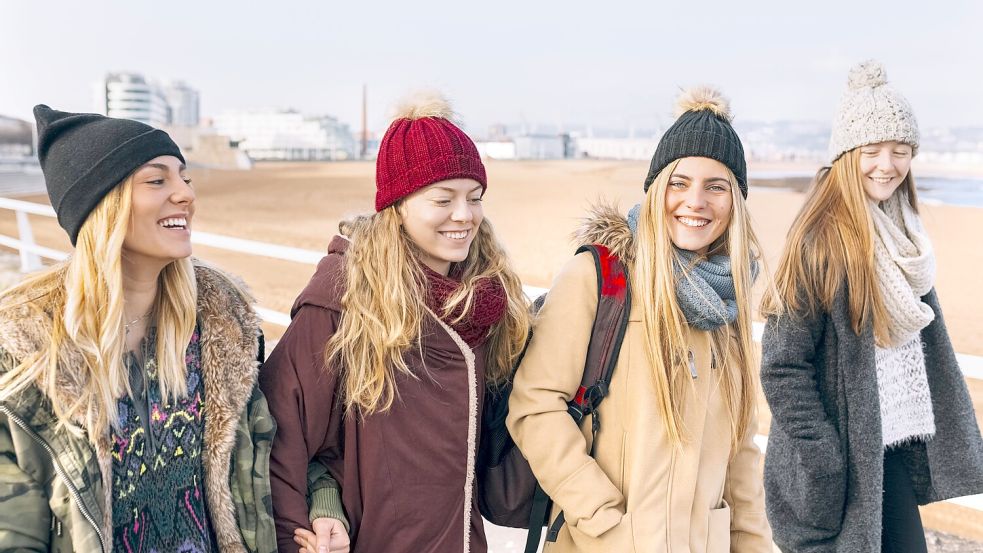 Nur nicht den Optimismus verlieren: vier junge Frauen am Strand. Foto: imago stock&people