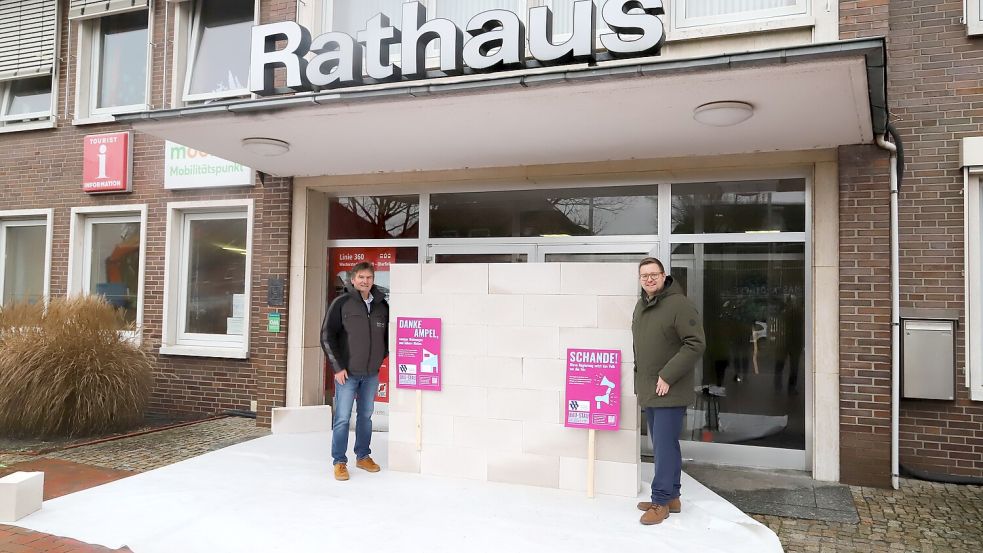In Barßel wurde die Eingangstür des Rathauses zugemauert. Unternehmer Hartmut Schoone (links) hatte die Aktion zuvor mit Bürgermeister Nils Anhuth (rechts) abgesprochen. Foto: Passmann