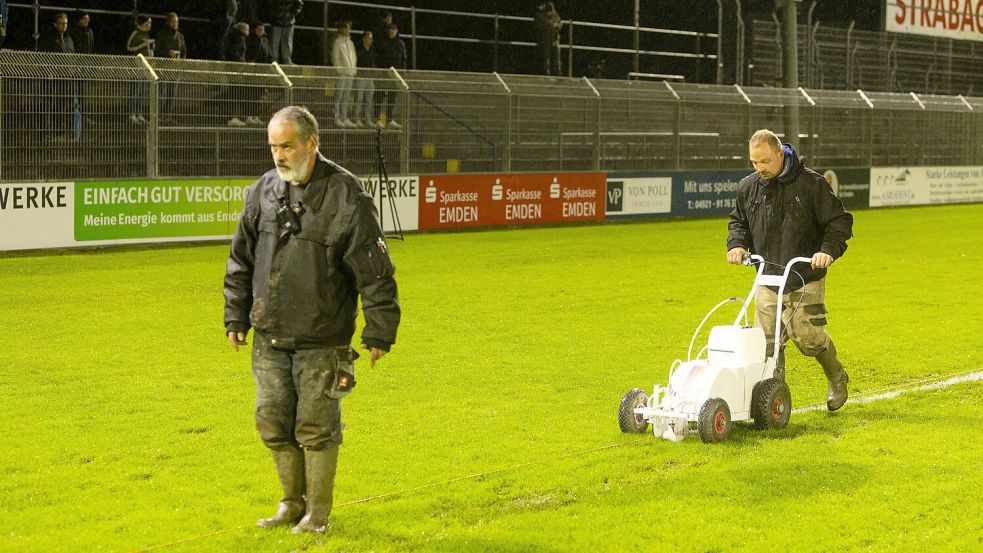 Marco Hufert (links) und Uwe Eeten betreten den Platz aktuell meistens mit Gummistiefeln. Das Foto zeigt sie beim Abkreiden des Spielfeldes vor der Partie gegen den TuS Bersenbrück. Fotos: Doden