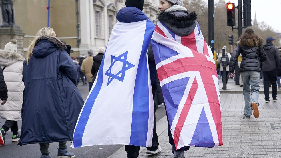 Zwei Demonstranten, eingewickelt in die Fahnen Israels und Großbritanniens, nehmen an einer Demonstration gegen Antisemitismus teil. Tausende Menschen sind in London gegen Antisemitismus auf die Straße gegangen. Foto: dpa/AP/Alberto Pezzali