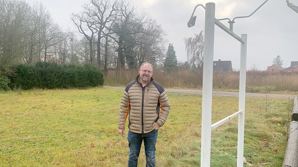 Saterlands Bürgermeister Thomas Otto steht auf dem ehemaligen Parkplatz des 2021 abgerissenen Strücklinger Hofs. Die Fläche, wo das Gebäude stand (im Hintergrund), ist inzwischen mit Bäumen zugewachsen. Foto: Kruse