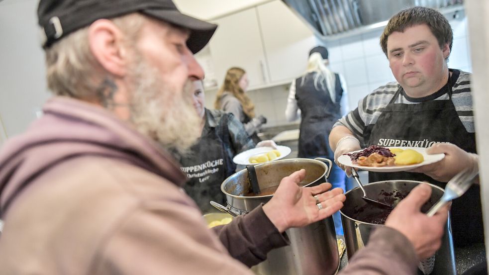 Henning Böke gibt einem Gast der Suppenküche Essen aus. Foto: Ortgies