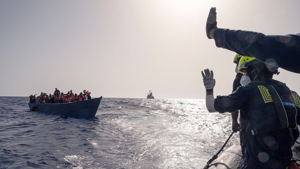 Crew-Mitglieder des Rettungsschiffes „Humanity 1“ der Organisation SOS Humanity retten Menschen aus einem überfüllten Boot. Foto: Arez Ghaderi/„SOS Humanity“/dpa