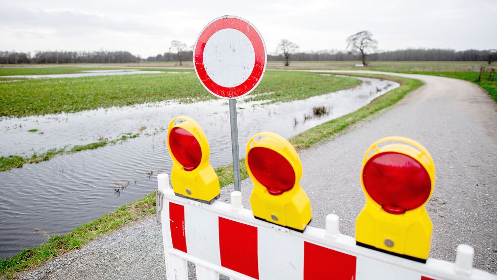 Eine Absperrbake steht in der Huntemarsch bei Oldenburg auf einem Feldweg. Über das Bümmersteder Fleth in der Huntemarsch wird eine dringend notwendige Entlastung der Hunte vorgenommen. Foto: Dittrich/DPA