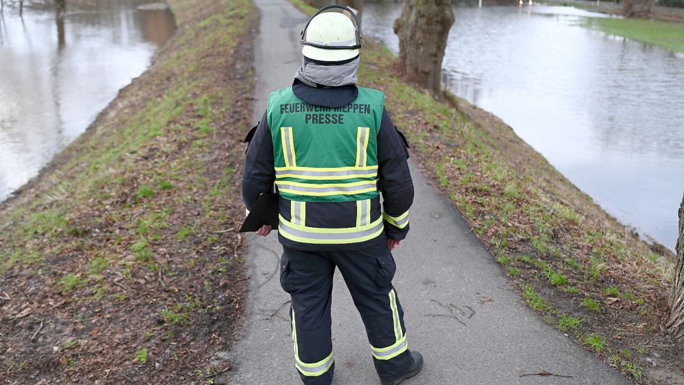 Sven Lammers, stellvertretender Leiter der Presse und Öffentlichkeitsarbeit der Feuerwehr, blickt am Donnerstag auf den durchweichten Emsdeich bei Meppen. Foto: Penning/DPA